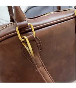 Detail of the golden metal hook and brown leather strap texture on this stylish backpack