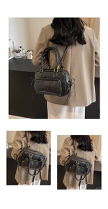 Detail of vintage black crossbody bag with wax leather texture and gold zippers