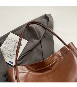 Detailed close-up of dark caramel brown leather tote bag with glossy finish for commute