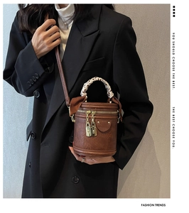 Sac seau cylindrique marron avec poignée enroulée de foulard en soie et zips dorés