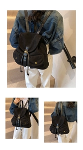 Detail of black canvas backpack showing leather drawstring and buckle closures on stairs
