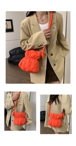 Close-up view of the orange puffed nylon drawstring bucket bag showing front and back details.