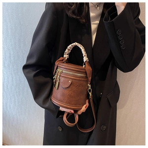 Détail du sac seau marron rétro avec foulard léopard sur l'anse et détails dorés