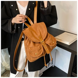 Detail eines braunen Vintage-Wildlederrucksacks mit Lederklappe und Seitentaschen