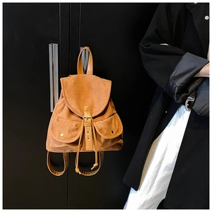 Detail eines braunen Wildlederrucksacks mit Schnallenklappe und magnetischen Seitentaschen