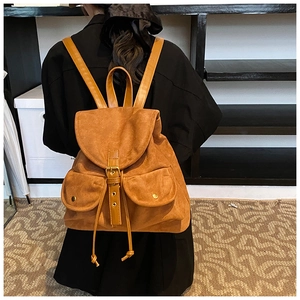Detail eines braunen Vintage-Wildlederrucksacks mit Schnallen und Druckknopftaschen