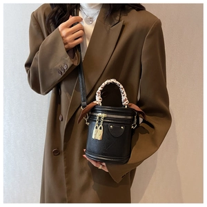 Detail of black leather bucket bag with leopard print silk scarf on the handle