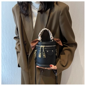 Détail du sac seau rétro avec poignée en foulard léopard et serrures dorées