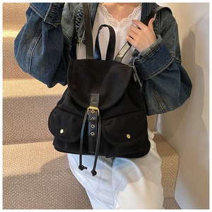 Detail eines schwarzen Vintage-Rucksacks mit Canvas-Body und Leder-Schnallenverschluss