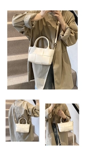 Detail of white woven leather handbag showing Intrecciato pattern and gold hardware