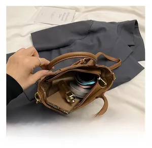 Internal capacity of the brown woven leather crossbody bag showing daily essentials inside