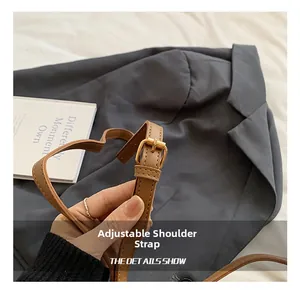 Detail of adjustable leather shoulder strap with gold buckle on brown crossbody bag