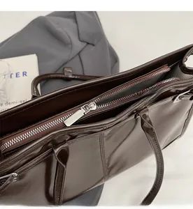 Close-up of smooth silver zipper and striped lining on a vintage brown tote bag