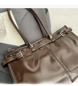 Close-up of dark brown oil wax leather tote bag with silver metal buckle details