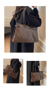 Detail of high-gloss dark brown wax leather tote bag with metallic buckle and retro finish