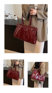Macro view of burgundy oil wax leather tote showing glossy finish and decorative stitching