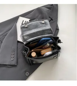 Draufsicht auf das Innenleben der schwarzen Ledertasche mit zwei Hauptfächern und Innenfutter