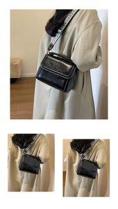 Detail of black PU leather square bag with white stitching and jacquard wide strap