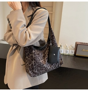 Detail view of leopard print tote bag with a small black coin purse on a model