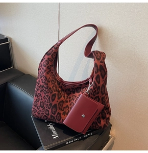 Detail view of brown leopard print hobo bag with a red leather mini pouch and metal snap