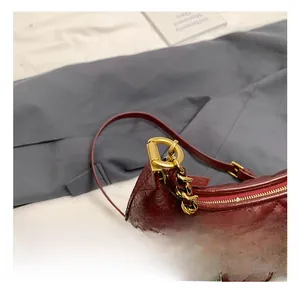 Detail shot of red quilted leather handbag with premium gold metal chain strap hooks