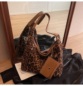 Detail of hobo bag featuring leopard print canvas with matching mini coin purse attachment