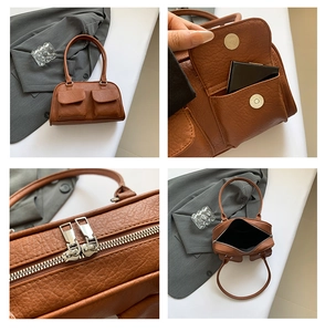 Close-up of litchi texture leather, magnetic buckles, and dual zipper detail on handbag