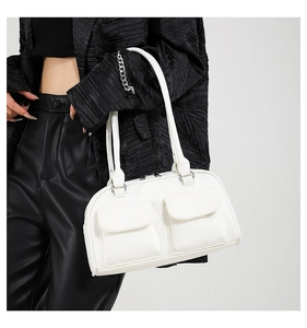 Detail of white faux leather shoulder bag with utility pockets on black jacket