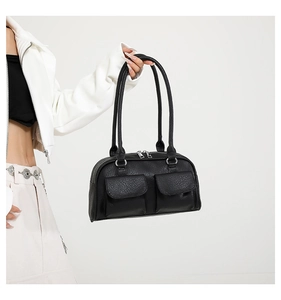 Detail of black pebbled leather handbag with double front zip pockets and long handles