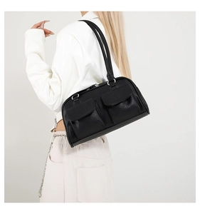Detail of black pebbled leather underarm bag with double front flap pockets on white jacket