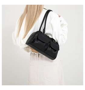 Model view showing the scale and fit of the black textured leather shoulder bag