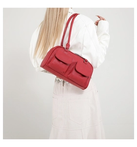 Rear view of a red vegan leather shoulder bag with two symmetric front flap pockets
