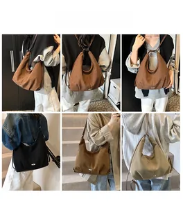 Macro shot of large matte leather hobo bag with metal buckle detail and dual shoulder straps