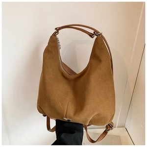 Detail of caramel brown suede tote bag showing the adjustable strap and metallic hardware
