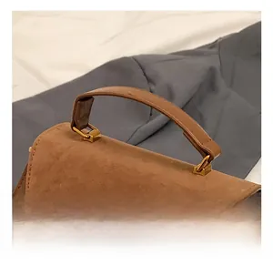 Detail view of the thickened brown PU matte handle with gold rectangular metal buckles