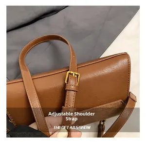 Detail of adjustable shoulder strap with gold-tone buckle on brown leather crossbody bag