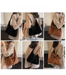 Suede hobo shoulder bags in black and brown with bow ribbon detail shown on model