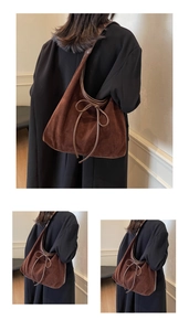 Detail of a deep brown suede tote bag featuring a leather bow and retro shoulder strap