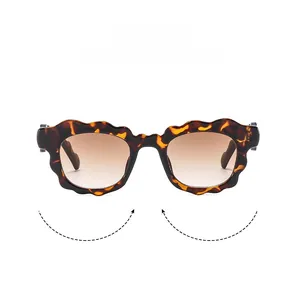 Detail of scalloped tortoiseshell sunglasses frames with brown gradient lenses