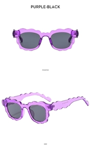 Detail view of scalloped wavy purple sunglasses frames and dark grey lenses for women