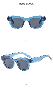 Detail view of wavy blue scalloped sunglasses frame and dark lenses from two angles