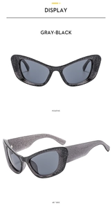 Close-up of Y2K cat-eye sunglasses in grey-black with silver glitter finish and grey lenses