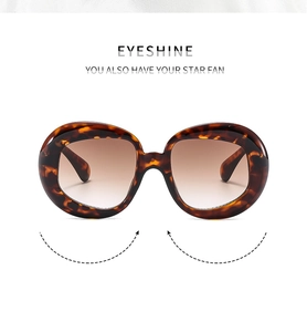 Detail of vintage oval leopard print sunglasses with elegant brown gradient lenses