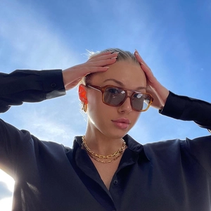 Classic square double-bridge sunglasses with gold chain necklace and blue sky backdrop