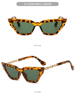 Détail de lunettes œil-de-chat écaille avec branches chaîne dorée et verres verts