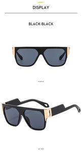 Detail showing black square frame sunglasses with gold hinge accents and geometry cutouts
