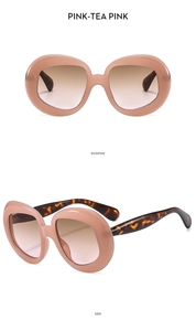 Detail view of pink oval retro sunglasses with tortoise temples and gradient lenses