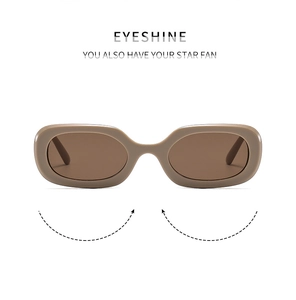 Close-up of retro oval sunglasses with deep brown glossy frames and dark lenses