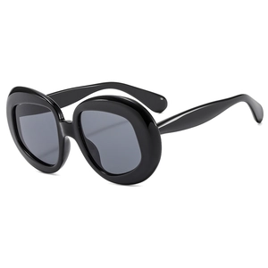 Elegant oversized oval vintage sunglasses for women with thick black frames and dark lenses