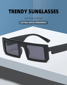 Detail of trendy black rectangular sunglasses with a thick frame on a minimalist pedestal